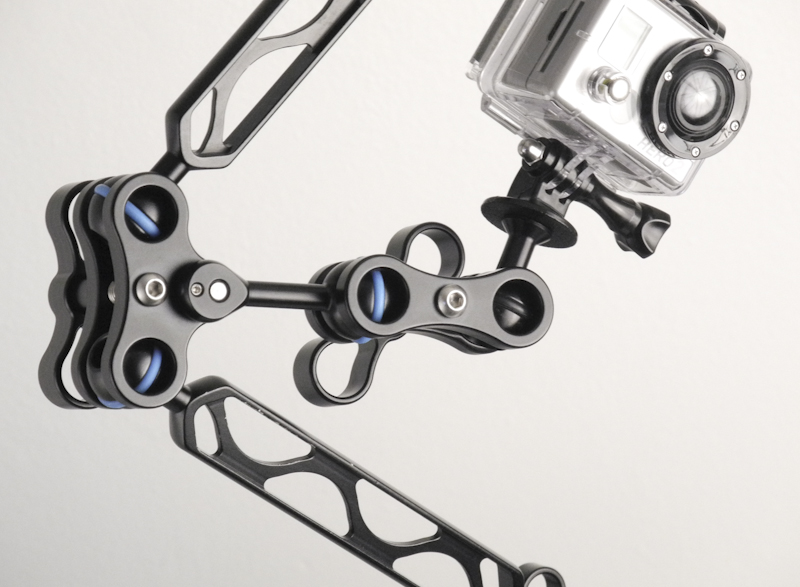 Close-up of a short clamp and flex arm system mounted to an underwater GoPro housing, showing compact rig components for camera stability and light attachment.